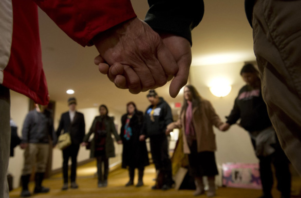 A group of aboriginal protesters hold hands during a prayer outside the National Roundtable on Missing and Murdered Indigenous Women and Girls Friday, February 27, 2015 in Ottawa. The Canadian Press