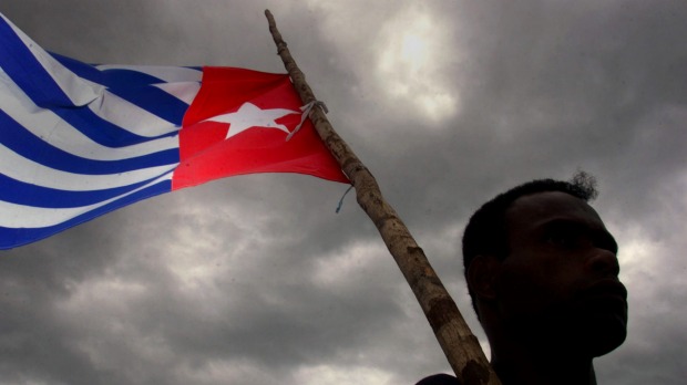 A Papuan holds the Morning Star independence flag, an act for which dissident Filep Karma was jailed for 15 years. Photo: Reuters