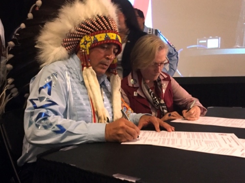 AFN National Chief Perry Bellegarde signs a memorandum of understanding with Indigenous Affairs Minister Carolyn Bennett during the AFN annual general assembly in Niagara Falls, Ont., on July 12, 2016. (Chris Glover/CBC)